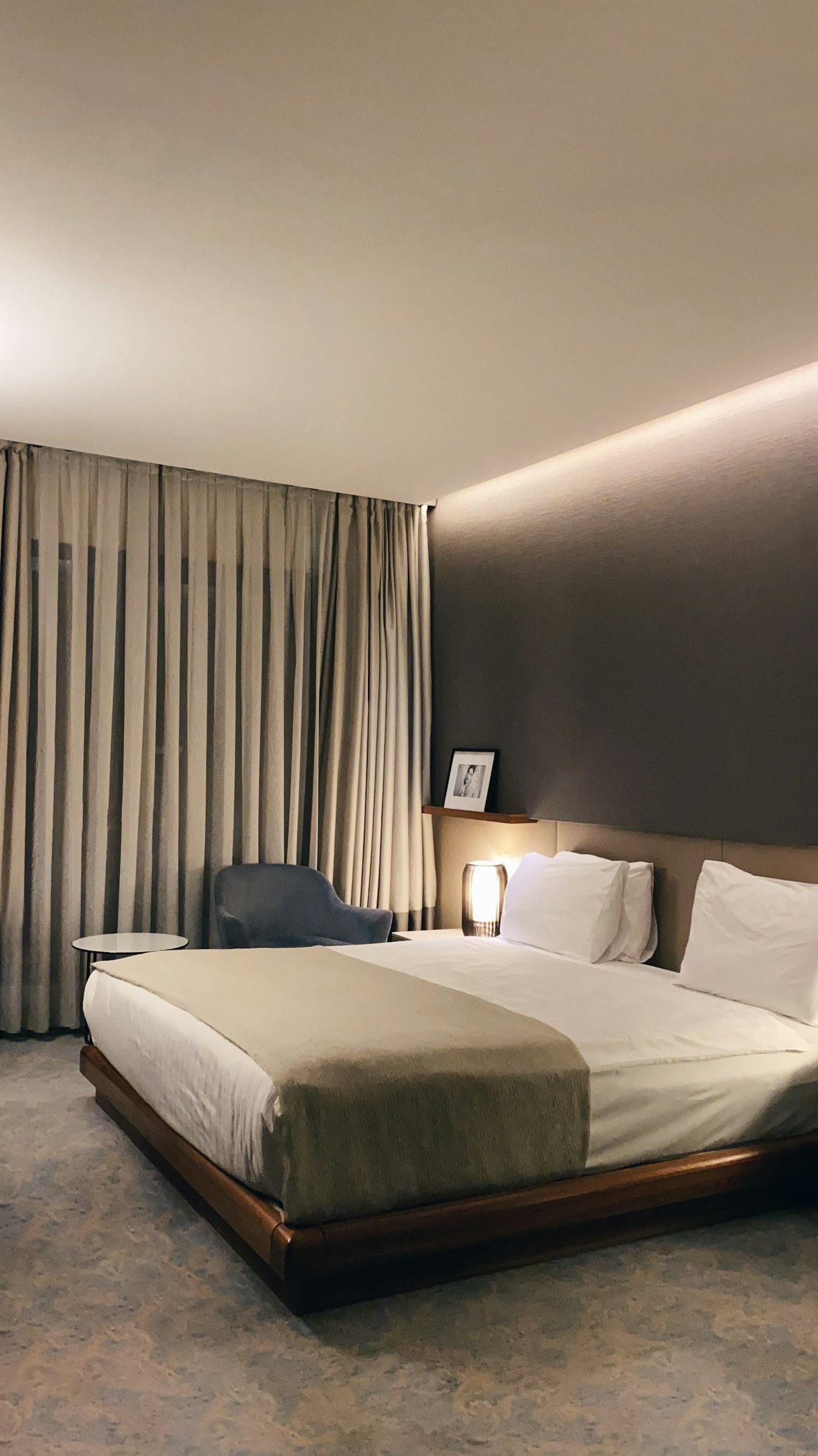 Warm guest room prepared with layered bedding and bedside light